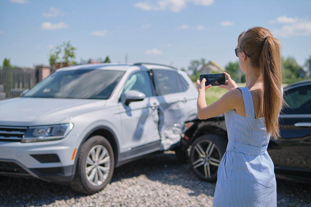 Woman Photographing Vehicle After Accident in Queens, NY